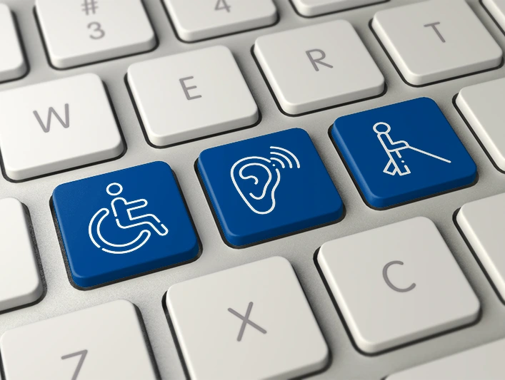 Bild einer Tastatur, auf deren Tasten ein Rollstuhlfahrer, ein Blinder und ein Hörgerät abgebildet sind